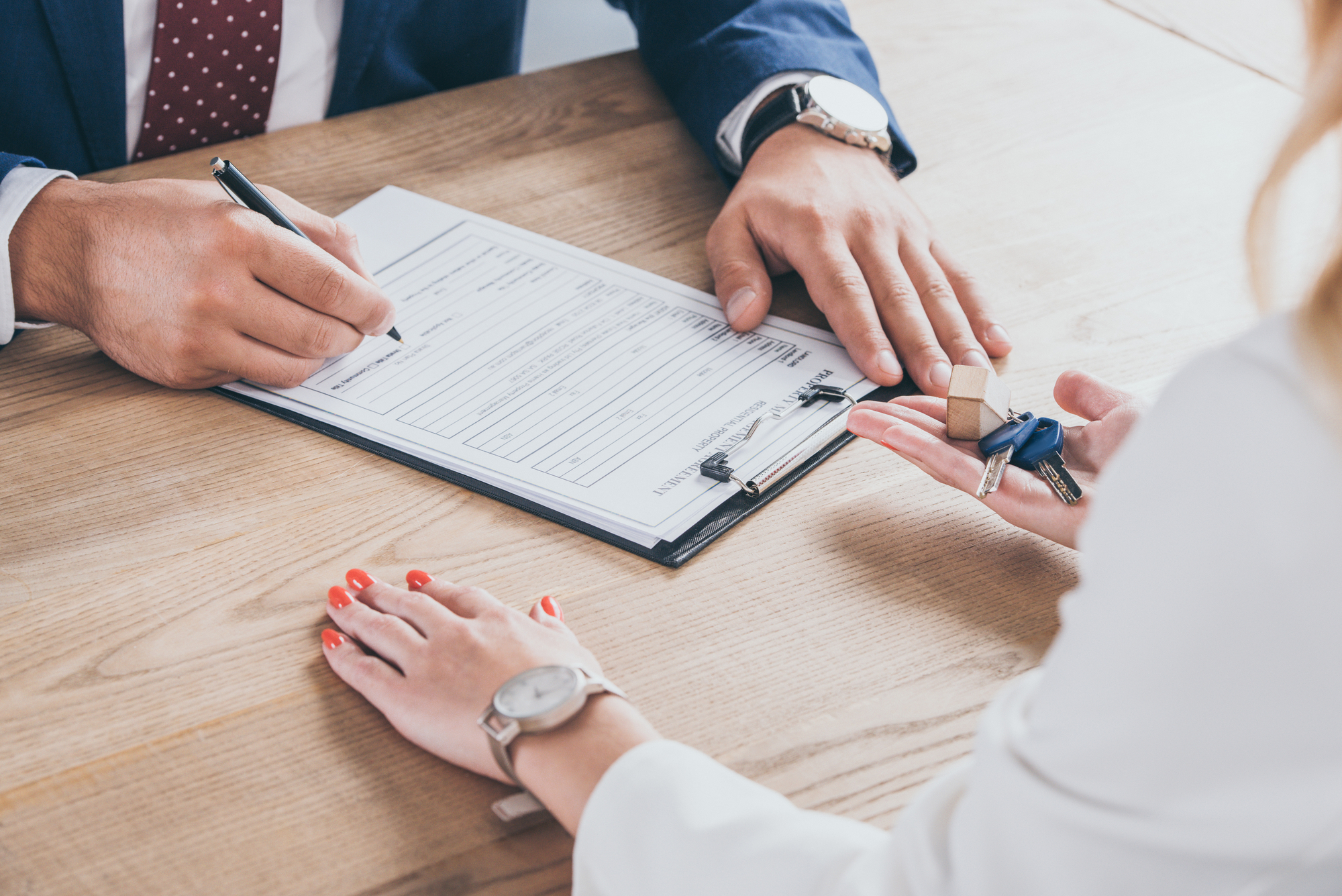 personne qui signe un papier d'acquisition de voiture d'occasion